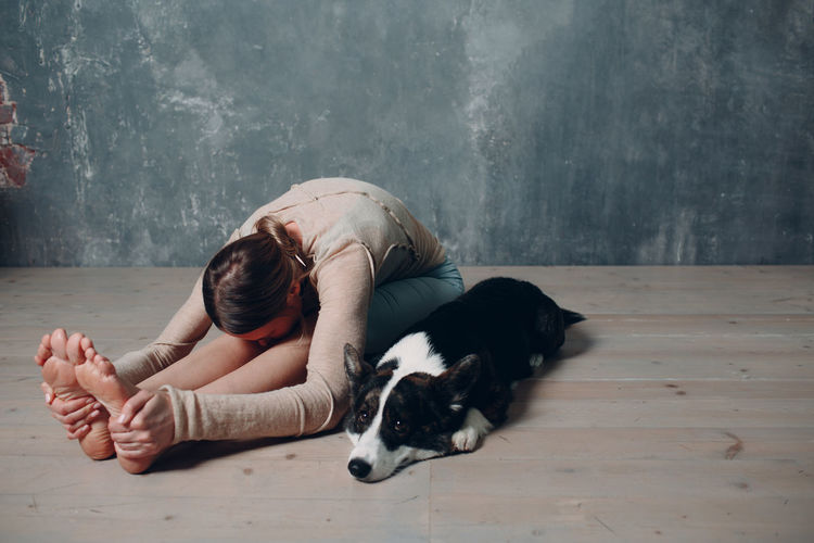 Woman with dog resting on floor