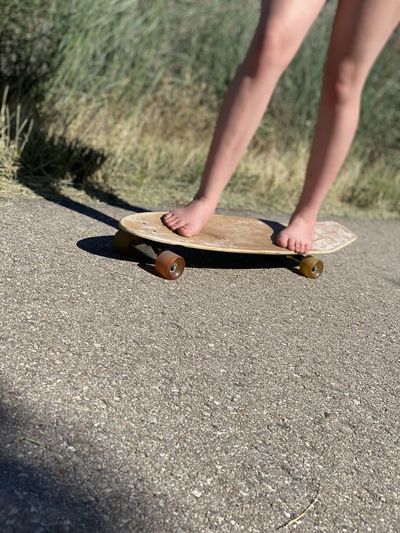 Youth skateboarding bare foot on a sunny day
