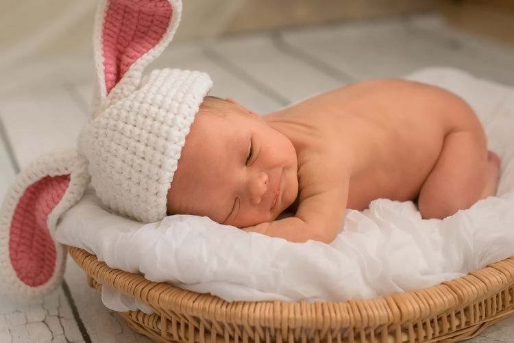 Close-up of newborn baby boy sleeping in wicker basket