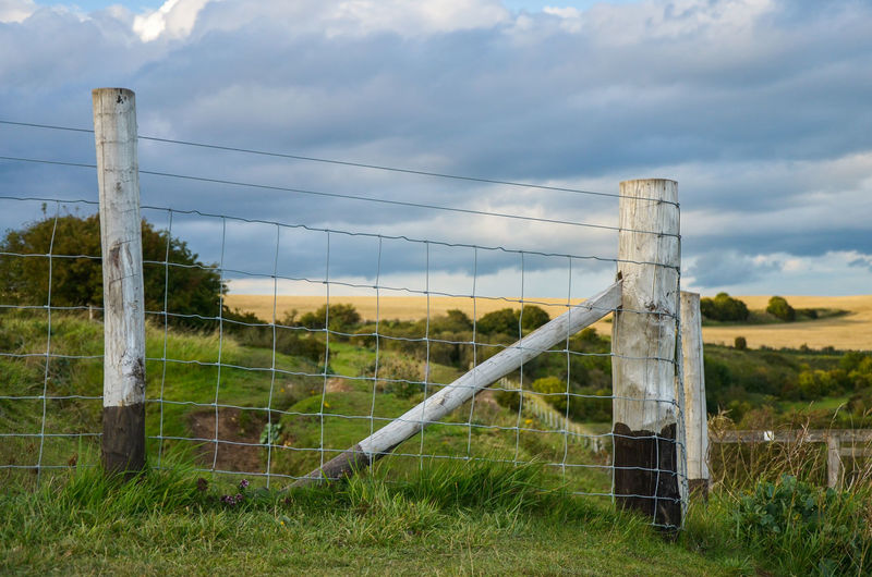 Fence on field against sky at the top of white cliffs in dover.