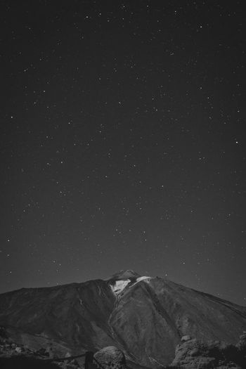 Low angle view of snowcapped mountain against sky at night