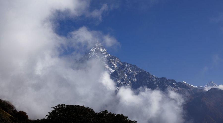 Low angle view of snowcapped mountains against sky