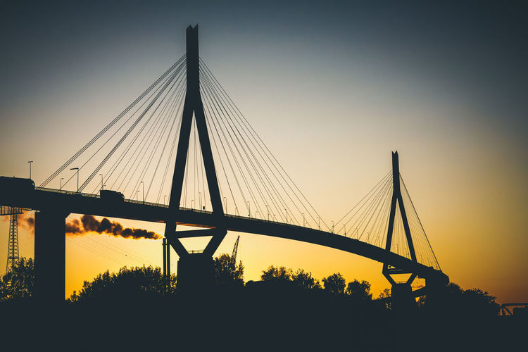 Silhouette kohlbrand bridge against sky during sunset