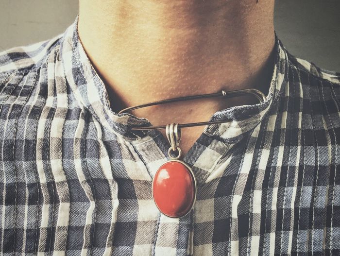 Midsection of woman with red pendant