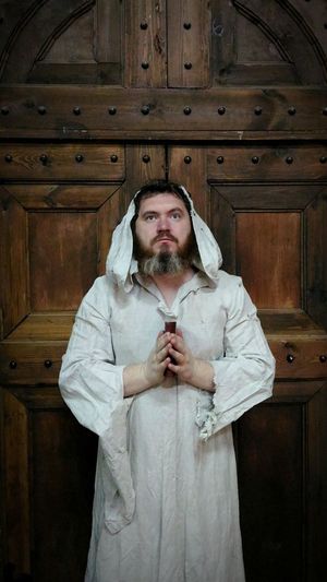 Priest holding bible against closed door