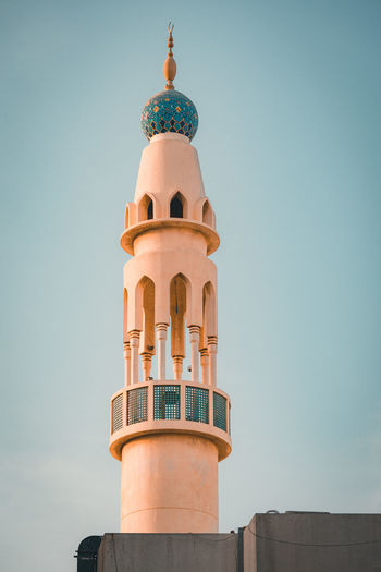 Low angle view of masjid  tower against sky