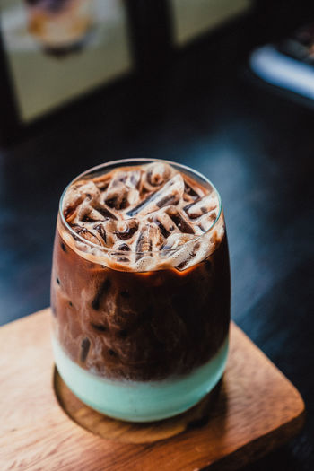 High angle view of iced coffee in glass on table