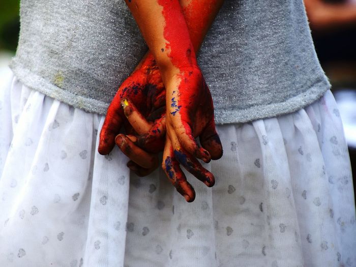 Midsection of woman with painted hands outdoors