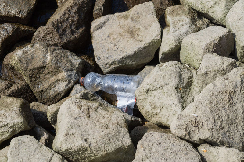 High angle view of empty bottle on rocks