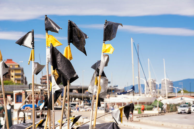 Panoramic view of flags hanging at harbor against sky