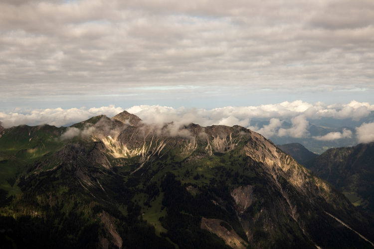 Scenic view of mountain range against cloudy sky