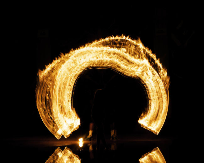 Silhouette man performing illuminated at night