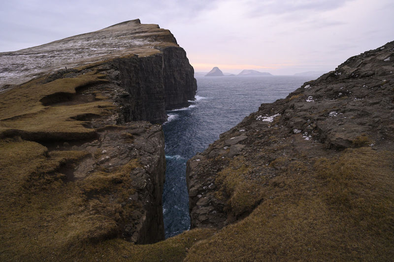 Rock formations on sea shore against sky