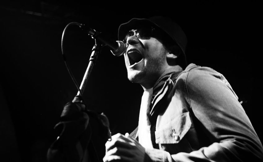 Low angle view of man wearing sunglasses while singing on stage