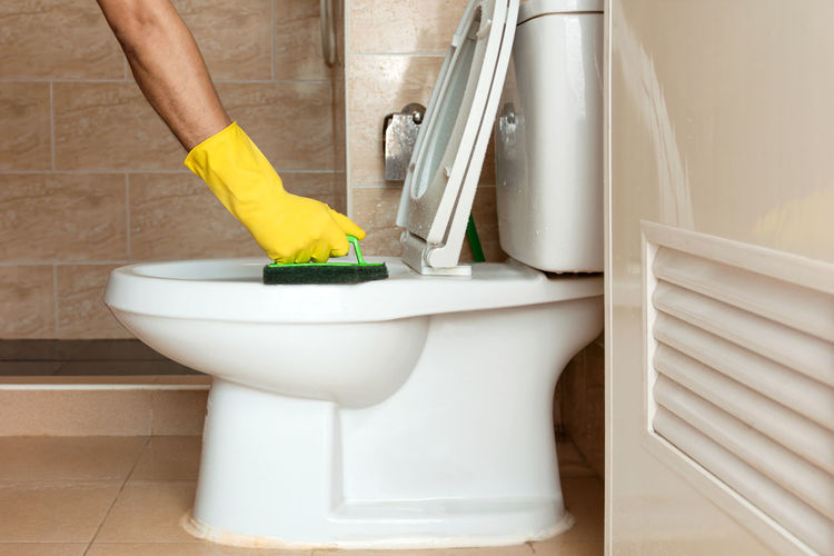 Cropped hand of person washing hands in bathroom