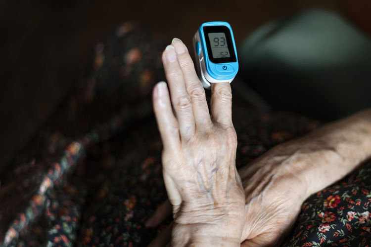 Midsection of senior woman with medical equipment on hand