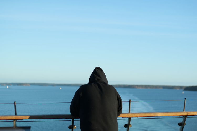 Rear view of man in sea against clear sky