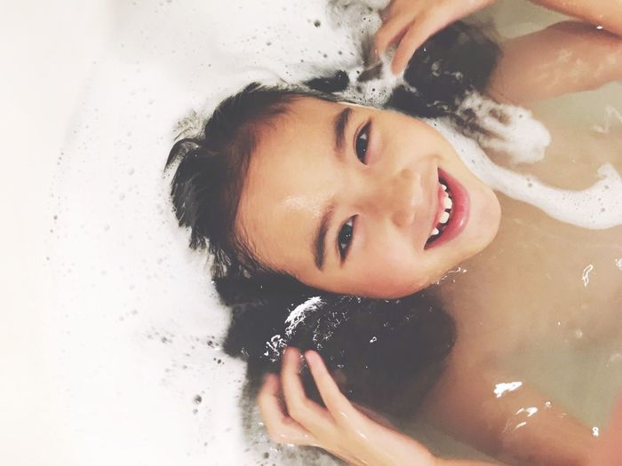 Portrait of happy girl in bathtub