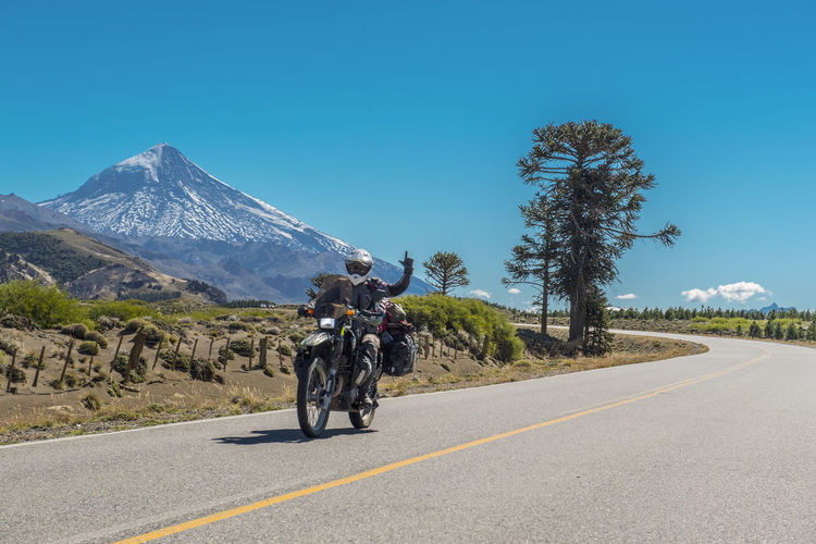 Woman on touring motorbike. lanin volcano in the back, argentina