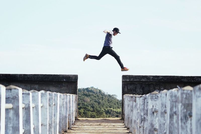 Full length of man jumping against sky