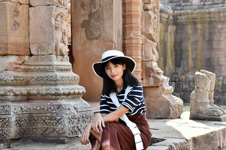 Portrait of young woman in front of historical building