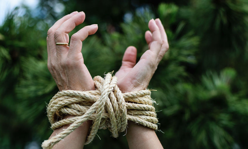 Close-up of hands tied with rope