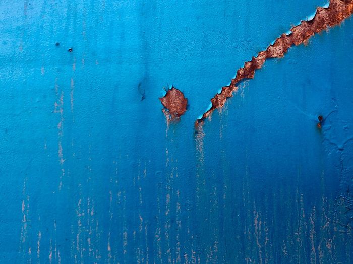 Scratched and rusted blue metal surface