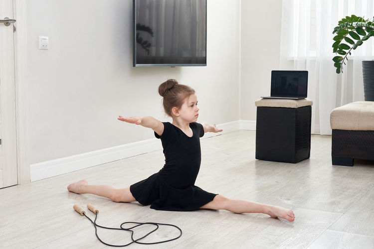 Girl looking away while doing split at home