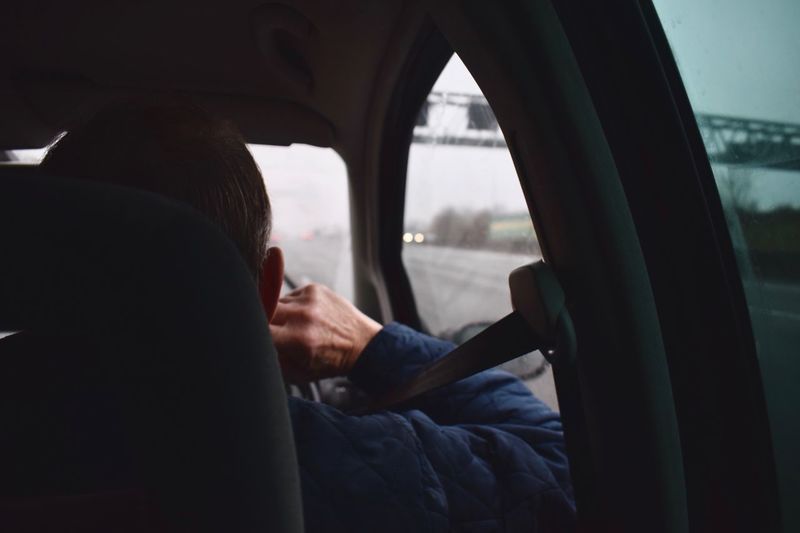 Rear view of man sitting in car