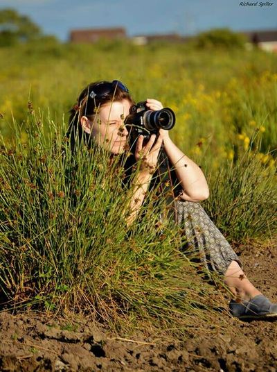 Photographer holding camera on field