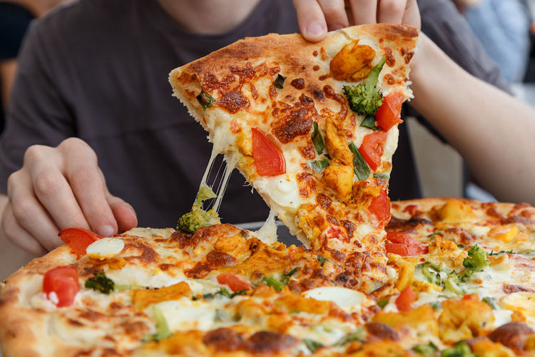 Midsection of man with pizza at table