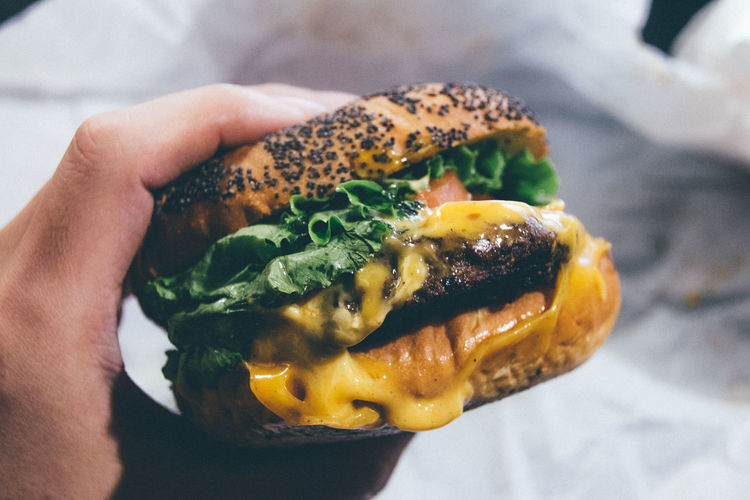 Cropped image of hand holding hamburger