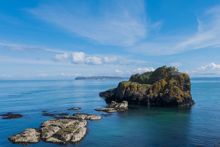 Scenic view of rock formation in sea against sky