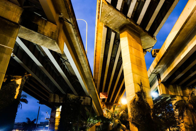 Low angle view of illuminated bridges at dusk