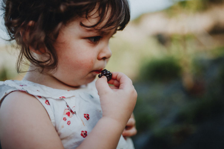 Little girl eating blackberries