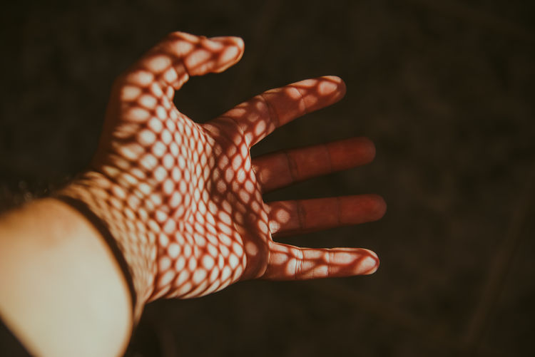 Close-up of human hand against black background