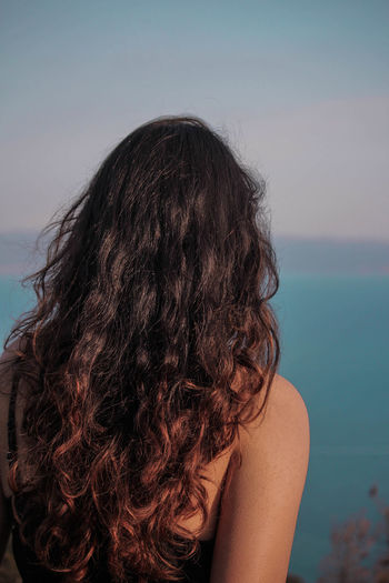 Rear view of woman standing against sea
