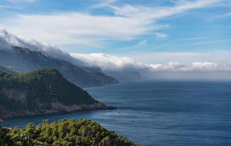 Scenic view of sea and mountains against sky