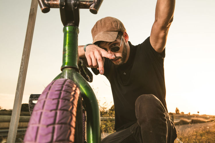 Portrait of man with bicycle on field 