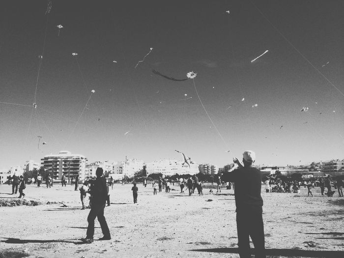 People at beach against clear sky