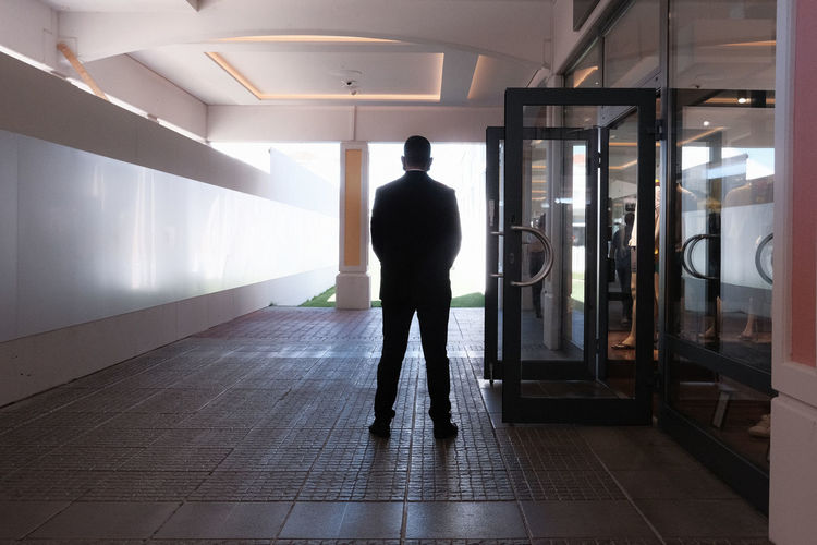 Rear view of man standing in corridor of building