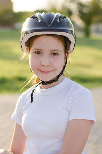 Portrait of a red-haired 11-year-old girl in a bicycle helmet.