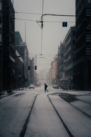 Man walking on street amidst buildings in city