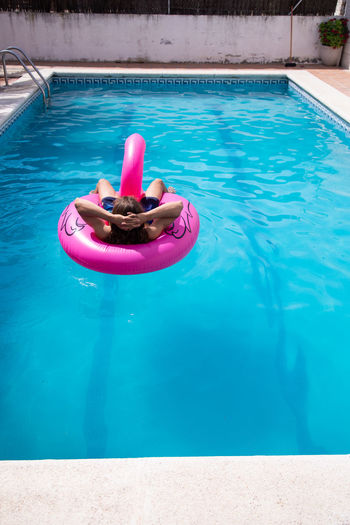 High angle view of woman floating in pool