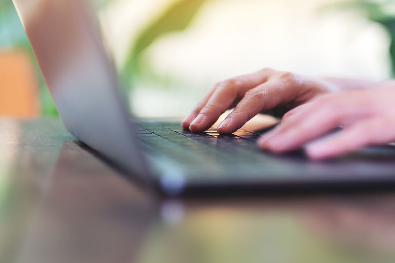 Midsection of man using laptop on table