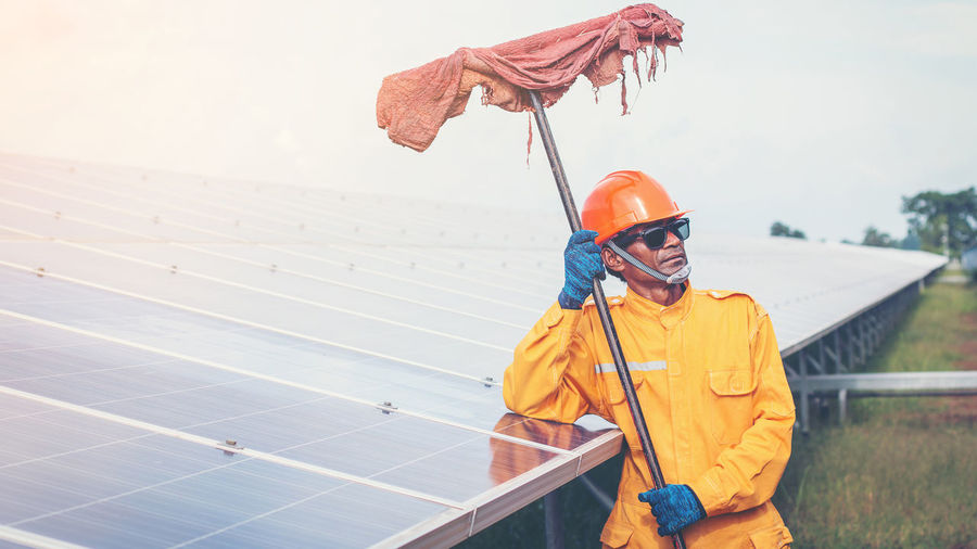 Manual worker working by solar panels