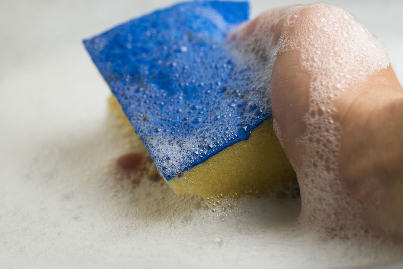 Cropped image of person holding cleaning sponge