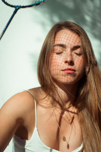 Close-up of beautiful young woman holding racket
