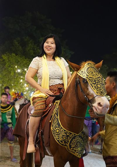 Young woman with people riding in traditional clothing