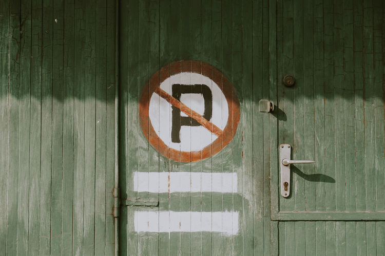 The wooden door of the store with a symbol of no parking